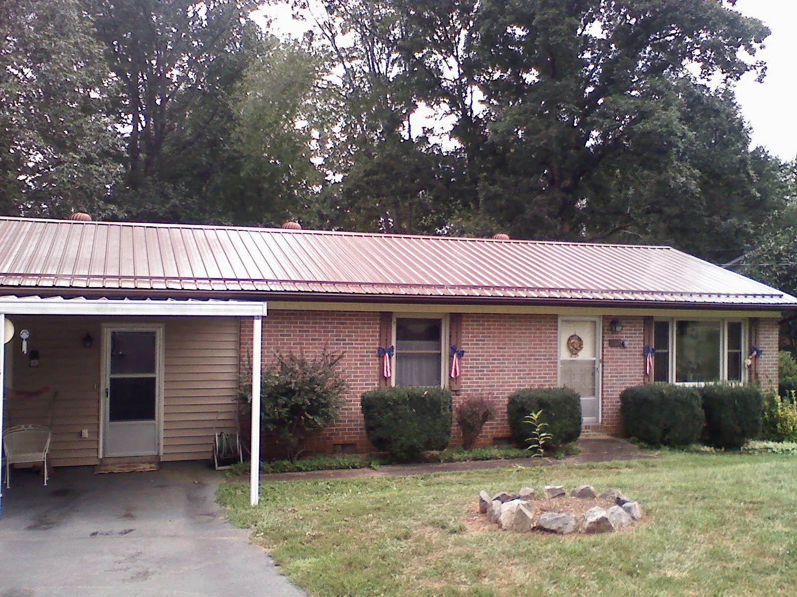 Bronze metal roof and carport on a brick ranch home — Roof Repair work by our crew in Maspeth